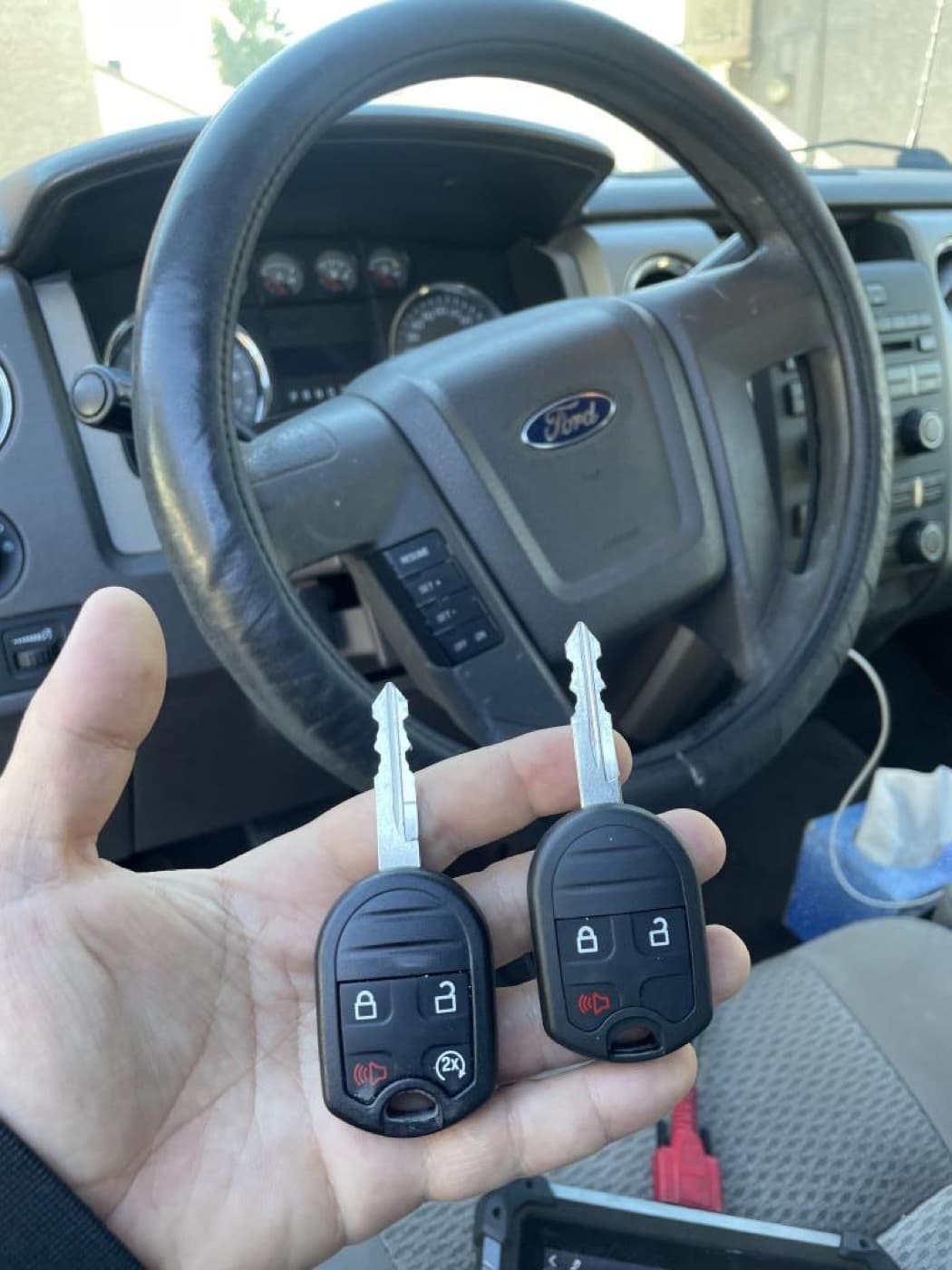 Two freshly programmed Ford F-150 key fobs held by 360 Locksmith LLC technician